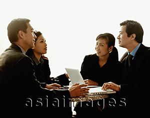 Asia Images Group - Executives meeting around table with laptop, white background.