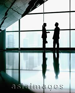 Asia Images Group - Executive pair in front of large window, silhouette.