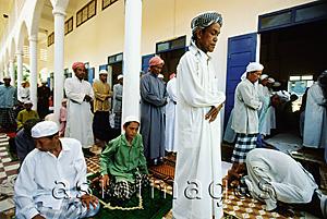 Asia Images Group - Cambodia, Kompong Cham, bowing Muslim worshippers spill outside main prayer hall.