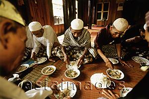 Asia Images Group - Cambodia, Phnom Penh, Muslims celebrating the return of pilgrims with a meal of rice and curry.
