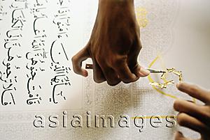Asia Images Group - Malaysia, Kuala Lumpur, man applying gold leaf onto manuscript of the Koran.
