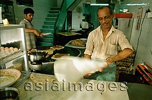 Asia Images Group - Singapore, a Muslim chef tossing murtabak, a thick pancake stuffed with meat, egg and onions at a food stall on Arab Street.