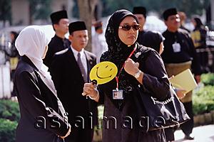 Asia Images Group - Brunei Darussalam, Borneo, A Muslim woman fanning herself to keep cool.