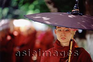 Asia Images Group - Myanmar (Burma), Yangon (Rangoon), A Buddhist monk walking with an umbrella on a sunny day.