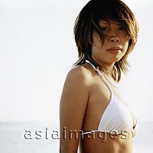 Asia Images Group - Tanned woman wearing white bikini at beach, portrait