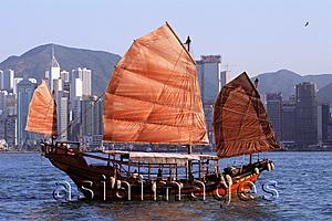 Asia Images Group - Hong Kong, Victoria Harbor, Chinese junk, buildings in background.