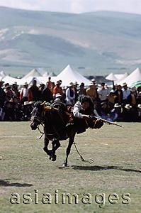 Asia Images Group - China, Szechuan (Sichuan), Kham region, Skilled horseman in traditional costume shooting from horse with musket during summer nomad festival.