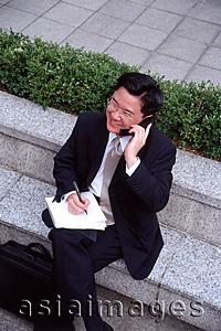Asia Images Group - Man in business suit, using mobile phone