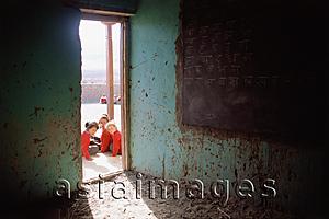 Asia Images Group - India, Ladakh, School girls sitting in front of doorway of classroom.