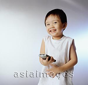 Asia Images Group - Boy, 3 years old holding remote control, smiling.