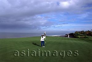Asia Images Group - Indonesia, Bali, Tanah Lot, Putting out on 13th green Nirwana Bali Golf Club. (grainy)