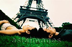 Asia Images Group - Young couple sleeping on grass, Eiffel Tower in background. (high-grained)