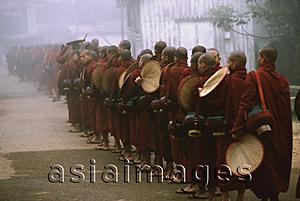 Asia Images Group - Myanmar (Burma), Bago, Buddhist monks with fans line up to collect alms.