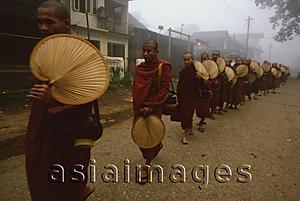 Asia Images Group - Myanmar (Burma), Bago, Buddhist monks holding fans line up to collect alms.