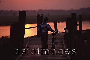 Asia Images Group - Myanmar (Burma), Mandalay, Man with bicycle crossing the U Bein bridge at sunset.