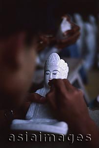 Asia Images Group - Myanmar (Burma), Mandalay, Craftsman painting marble Buddha statue. (Grainy)