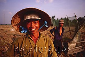 Asia Images Group - Vietnam, Outside Vinh Long, Mekong delta, Smiling rice farmers at rice harvest / threshing time.