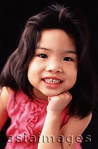 Asia Images Group - Young girl with hand on chin, toothy smile