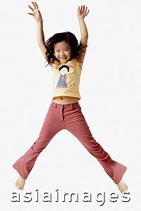 Asia Images Group - Girl jumping in the air with outstretched arms.