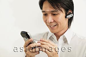 Asia Images Group - Man using PDA, smiling