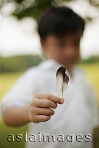 Asia Images Group - Young boy holding feather