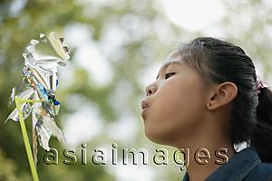 Asia Images Group - Young girl blowing a pinwheel