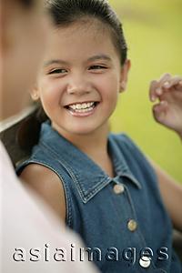 Asia Images Group - Young girl smiling, mother on foreground