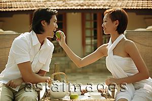 Asia Images Group - Young woman feeding young man.