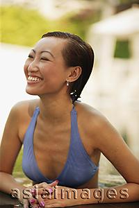Asia Images Group - Young woman in a  swimming pool, smiling