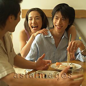 Asia Images Group - Friends at home, eating sushi
