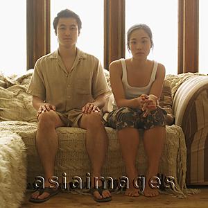 Asia Images Group - Couple sitting apart, home interior
