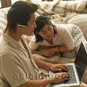 Asia Images Group - Couple at home, man using laptop