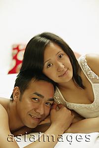 Asia Images Group - Couple on bed, looking at camera