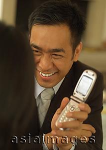 Asia Images Group - Man showing mobile phone to woman