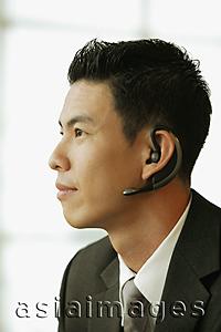 Asia Images Group - Young man, profile, using hands free device