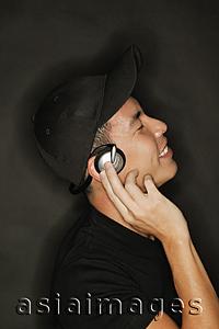 Asia Images Group - Young man with headphones, black background