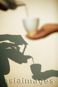 Asia Images Group - Pouring tea, shadow in the background