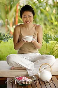 Asia Images Group - Young woman holding teacup, portrait