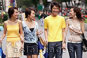 Asia Images Group - Friends walking side by side, talking, carrying bags