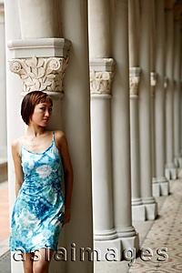 Asia Images Group - Young woman, leaning against column, looking away
