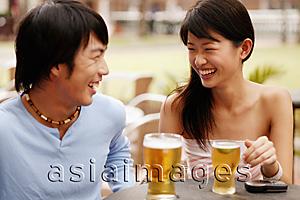 Asia Images Group - Couple sitting at cafe, drinks in hand