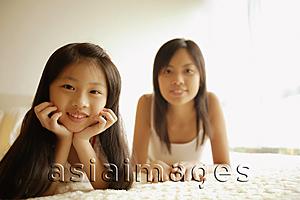Asia Images Group - Mother and daughter in bedroom, looking at camera