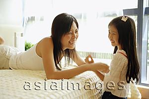Asia Images Group - Mother and daughter in bedroom, mother tickling daughter