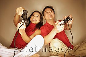 Asia Images Group - Man and woman playing with handheld video game