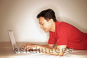 Asia Images Group - Man using laptop, profile