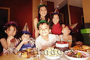 Asia Images Group - Young boy at a birthday party, surrounded by friends
