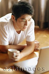 Asia Images Group - Young man looking at laptop,