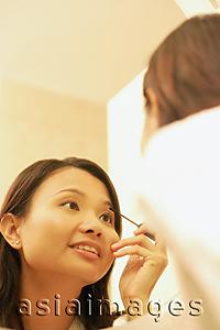 Asia Images Group - Woman putting on make-up