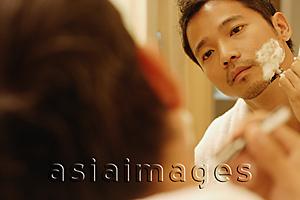 Asia Images Group - Young man shaving, looking in mirror, over the shoulder view
