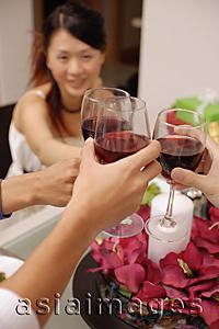 Asia Images Group - Friends raising wine glass, toasting across table